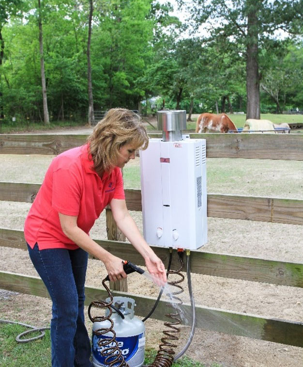 A woman is using Portable Tankless Water Heater for her horses